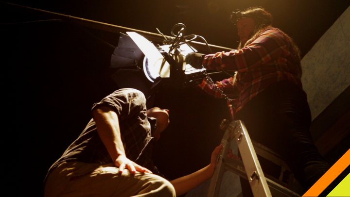 Two students work on lighting.