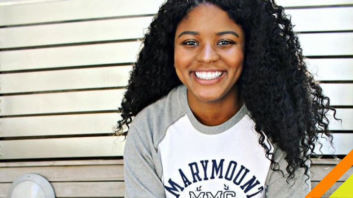 Student sitting and smiling at camera. 